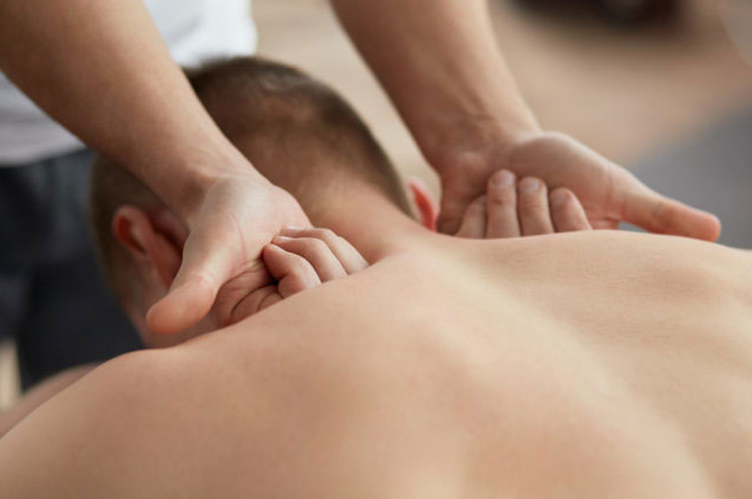 Deep tissue massage — firm focused pressure with both hands on the upper back at Blue Bay SPA Winter Park