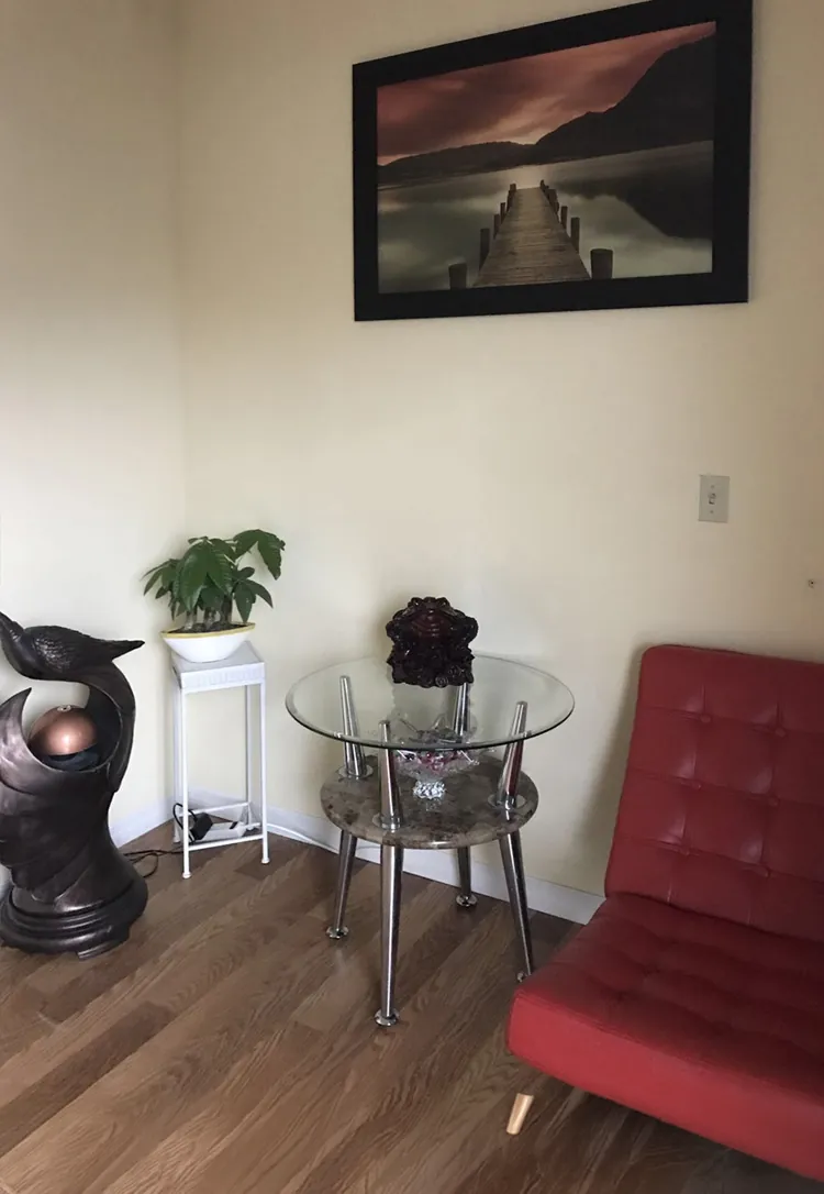 Waiting corner with a red chair at Blue Bay Massage Spa in Winter Park, FL